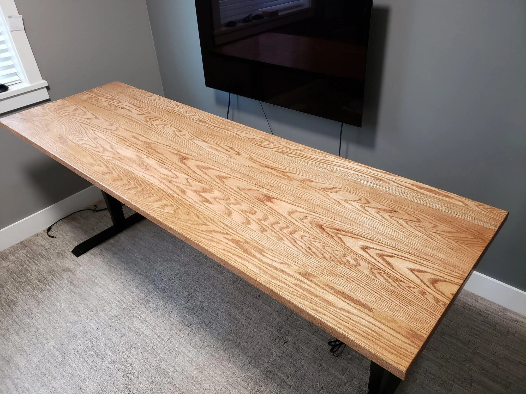 Finished Red Oak tabletop installed on a sit-stand desk